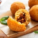 arancini di riso serviti su in tagliere in legno