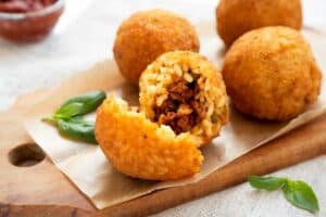 arancini di riso serviti su in tagliere in legno