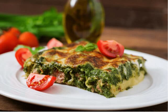 piatto di cannelloni ripieni con carne macinata conditi con salsa di pomodoro