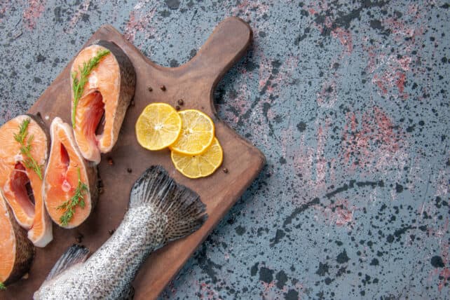 pesce spada e salmone su tagliere in legno