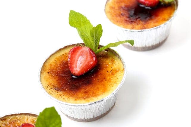 Coppette di crema catalana guarnite con fragole