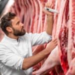 giovane uomo che controlla la frollatura della carne