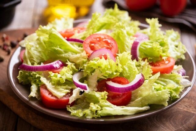 Piatto di insalata verde con pomodori, cipolle