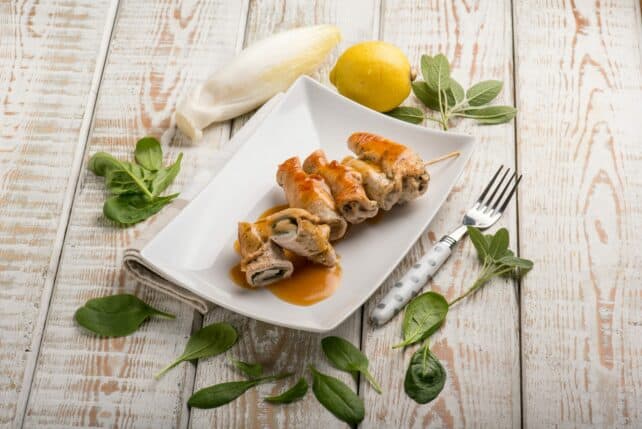 piatto con involtini di tacchino allo zafferano con spinaci e noci