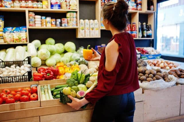 giovane donna al supermercato di fronte allo scaffale dei prodotti