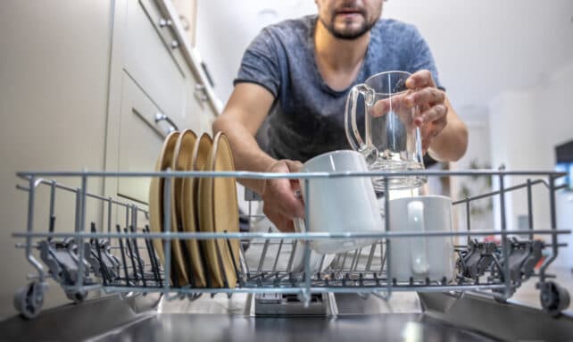 uomo che toglie i piatti dalla lavastoviglie