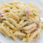 piatto di penne prosciutto e piselli