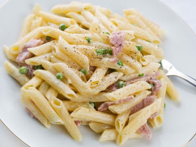 piatto di penne prosciutto e piselli