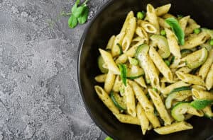 piatto di penne con verdure, zucchine e basilico