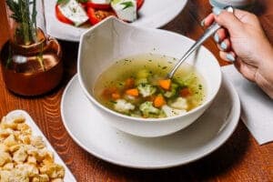 piatto di minestrone alla rustica accompagnato da crostini di pane