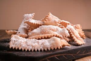 cenci di carnevale fritti su tagliere in legno - chiacchiere di carnevale