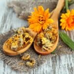 fiori di calendula su cucchiaio in legno