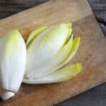 cesto di insalata belga su tagliere in legno