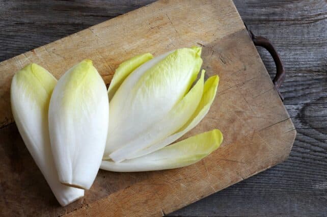 cesto di insalata belga su tagliere in legno