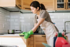 giovane donna che pulisce il piano della cucina