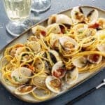 piatto di spaghetti allo scoglio accompagnati da vino bianco