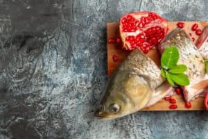 trota fresca con melagrana su tagliere in legno