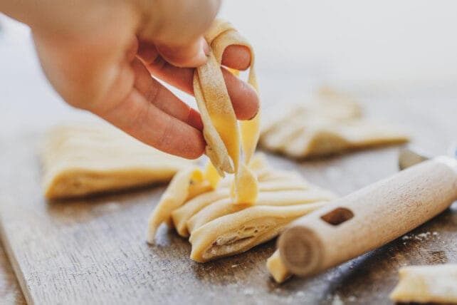 mani che preparano pasta fresca